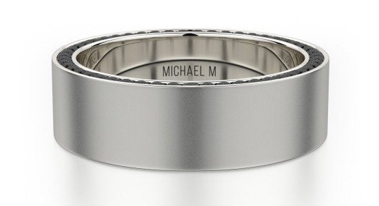 A titanium men’s wedding band by Michael M with black diamonds on the top, available at The Wedding Ring Shop.