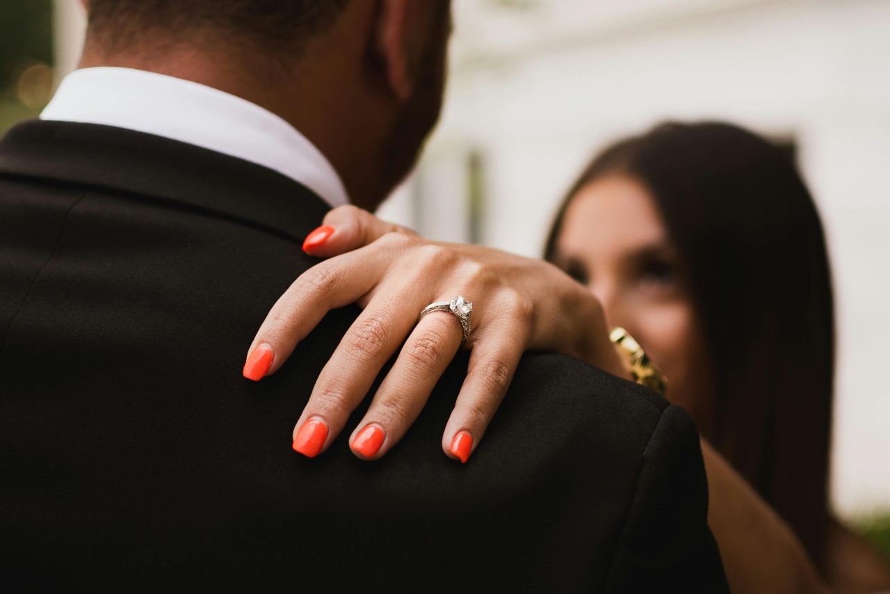 A close-up of a newlywed couple dancing, with emphasis on the engagement ring on the bride’s hand. A close-up of a newlywed couple dancing, with emphasis on the engagement ring on the bride’s hand.