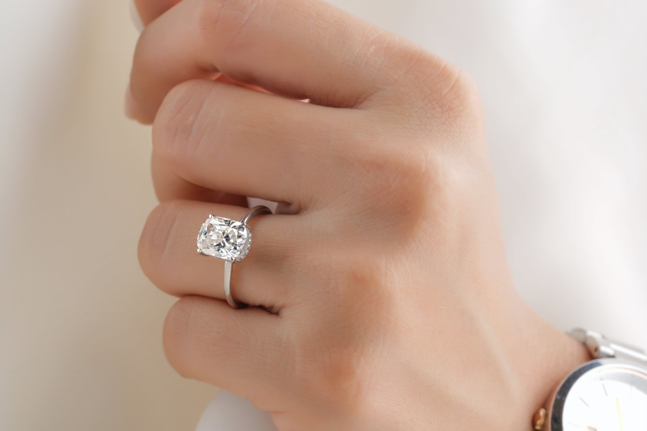 A radiant platinum engagement ring with hidden halo of diamonds under the center stone