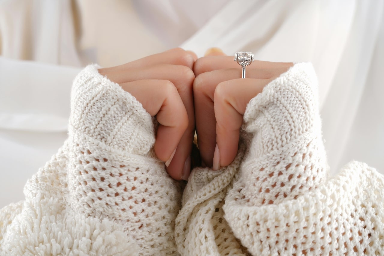 A micro halo of diamonds along the platinum setting of this cushion cut engagement ring