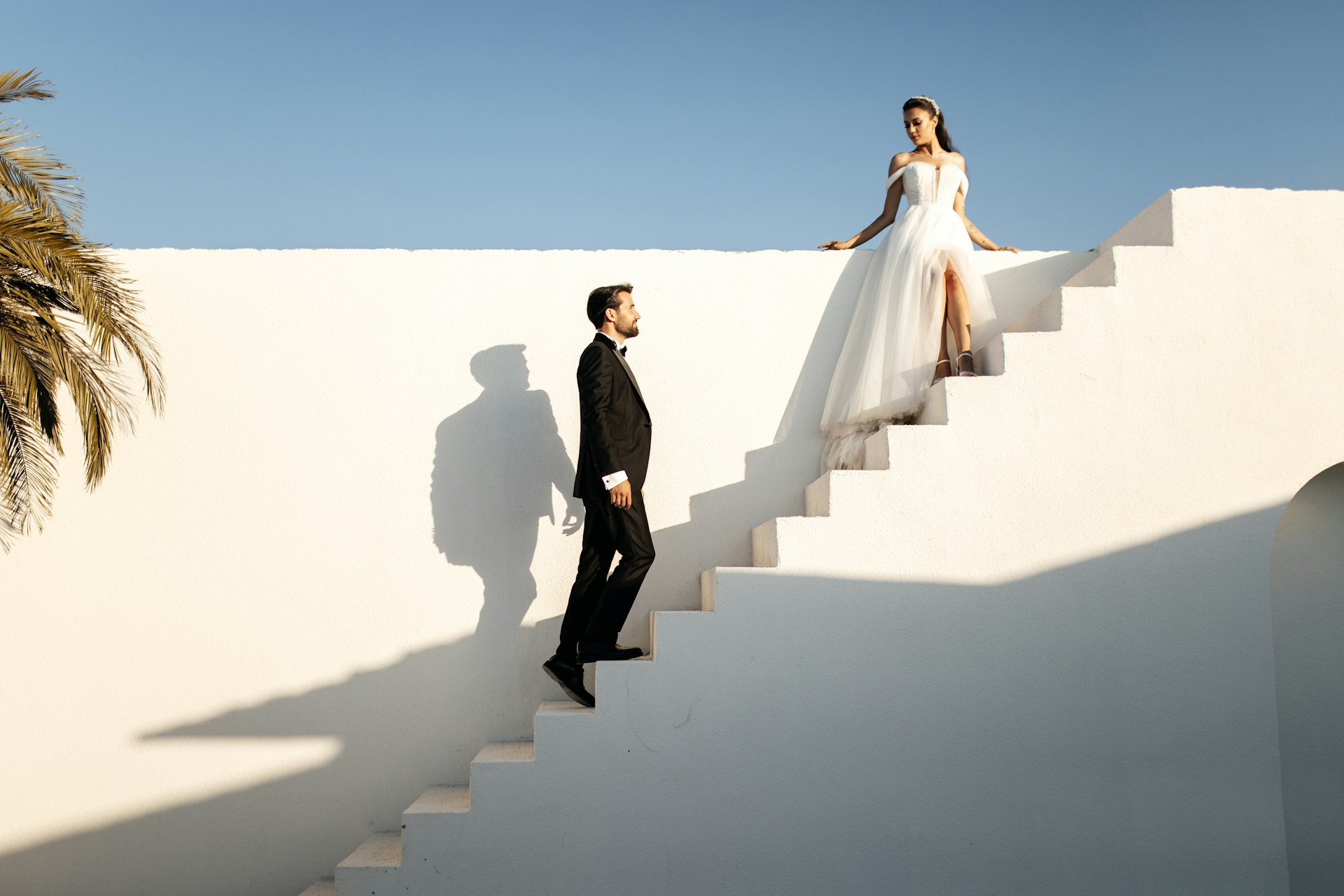 a groom ascending a staircase to meet his bride at the top