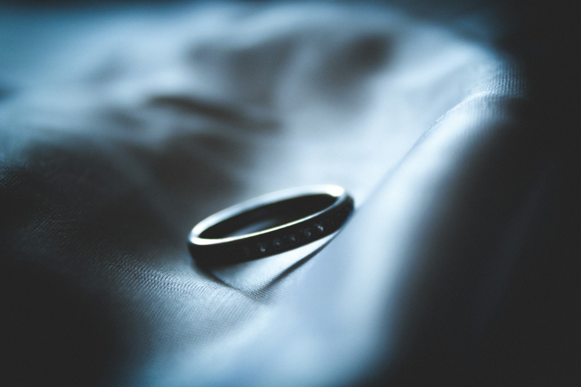 a black wedding band on a light surface