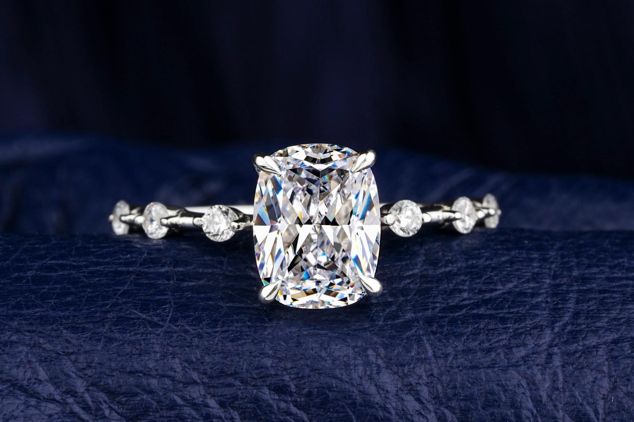 A close-up image of an engagement ring with a large, radiant cut center stone.